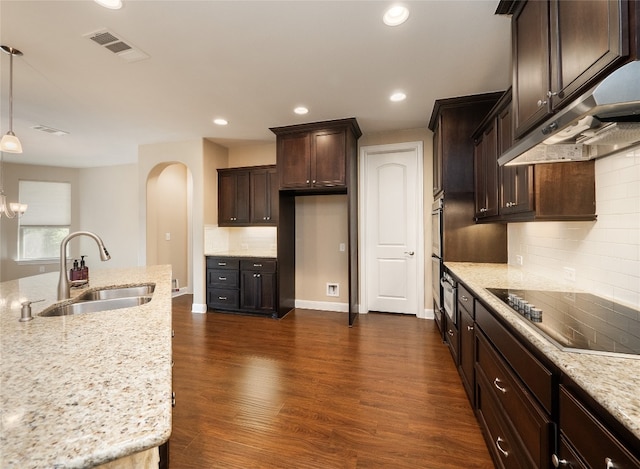 kitchen featuring visible vents, dark wood-type flooring, arched walkways, black electric cooktop, and a sink