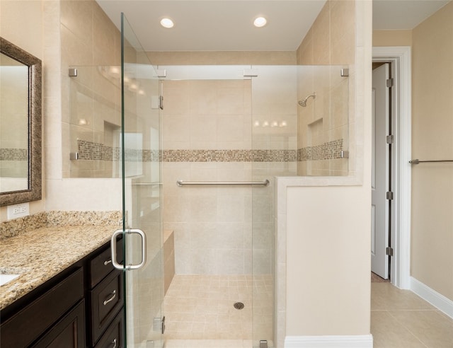 bathroom with tile patterned floors, recessed lighting, a shower stall, baseboards, and vanity