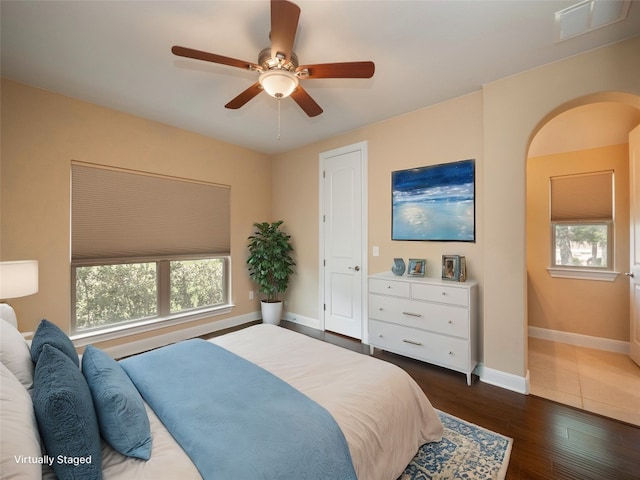 bedroom featuring visible vents, multiple windows, baseboards, and dark wood-style flooring