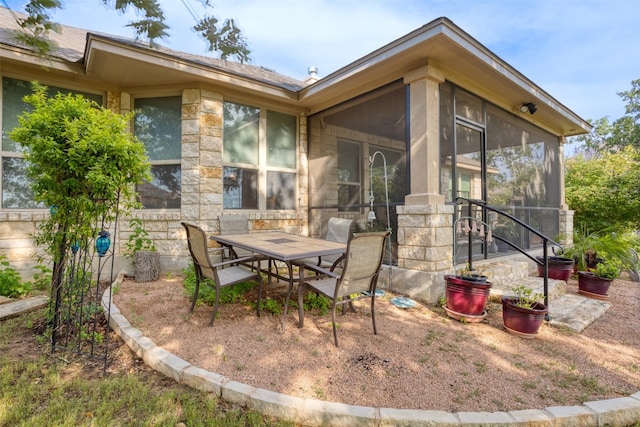 back of property featuring outdoor dining space and a sunroom