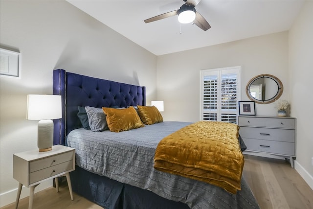 bedroom with baseboards, wood finished floors, and a ceiling fan