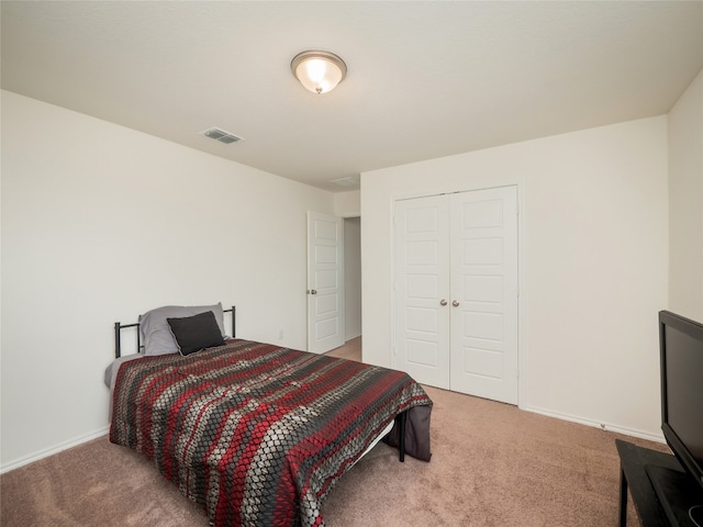 bedroom with a closet, carpet flooring, baseboards, and visible vents