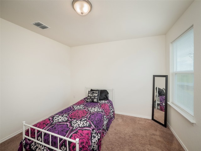 carpeted bedroom featuring visible vents and baseboards