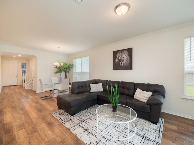 201 Teller Dr, Lockhart, TX 78644 - living area featuring wood finished floors, a chandelier, ornamental molding, arched walkways, and baseboards