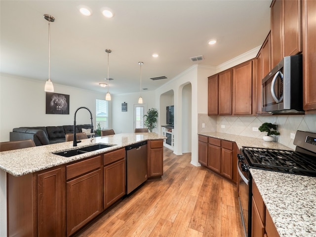 kitchen with tasteful backsplash, visible vents, light wood-type flooring, appliances with stainless steel finishes, and a sink