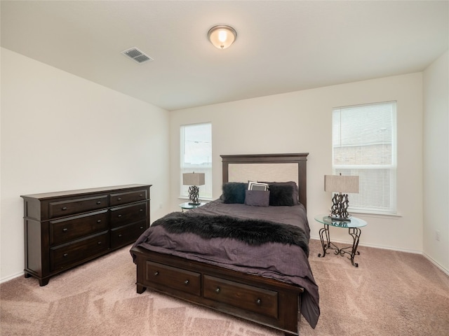 bedroom with visible vents, baseboards, and light colored carpet