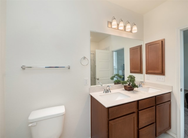 full bath featuring double vanity, toilet, and a sink