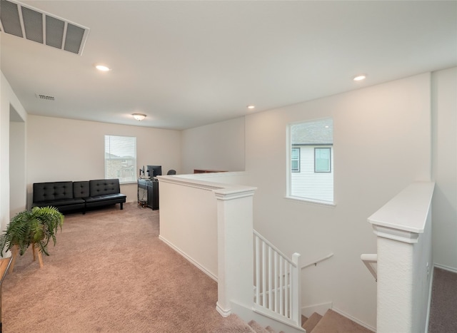 hall with recessed lighting, visible vents, an upstairs landing, and carpet flooring