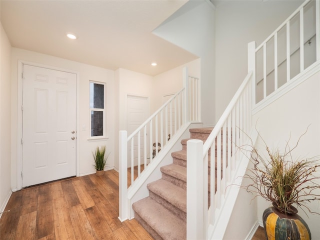 foyer with hardwood / wood-style flooring, stairway, recessed lighting, and baseboards