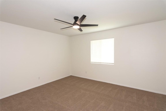 unfurnished room featuring dark carpet and a ceiling fan