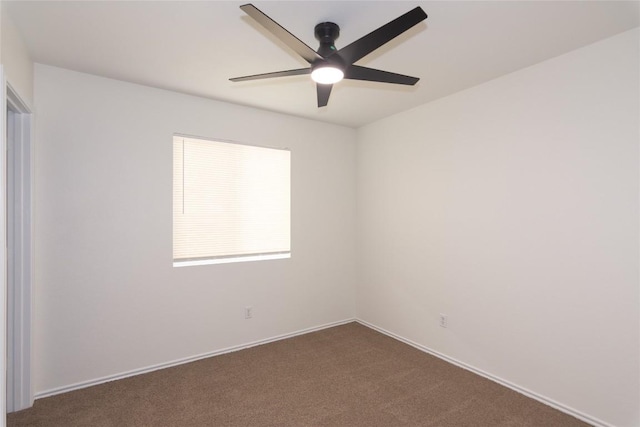 spare room featuring a ceiling fan and dark colored carpet