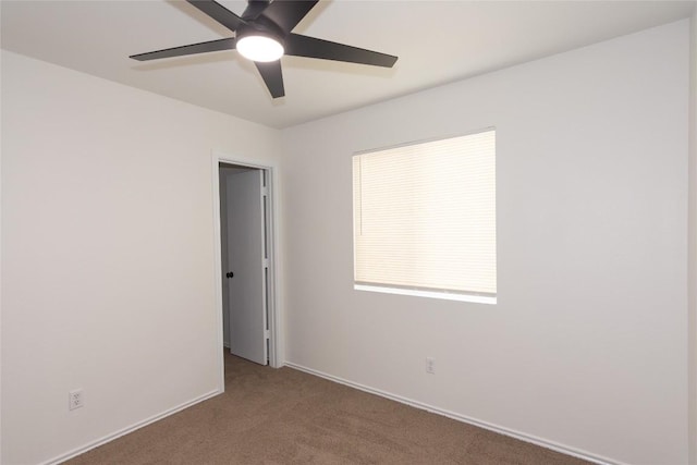 spare room with baseboards, carpet, and ceiling fan