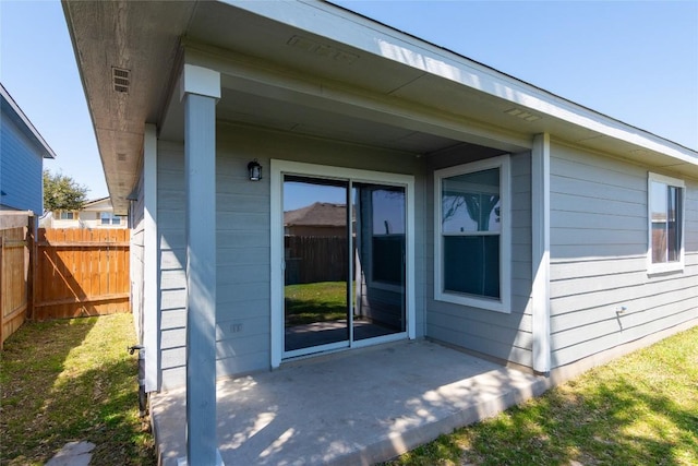 entrance to property with a patio area and fence