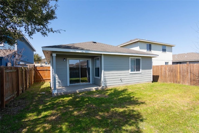 rear view of house with a lawn and a fenced backyard