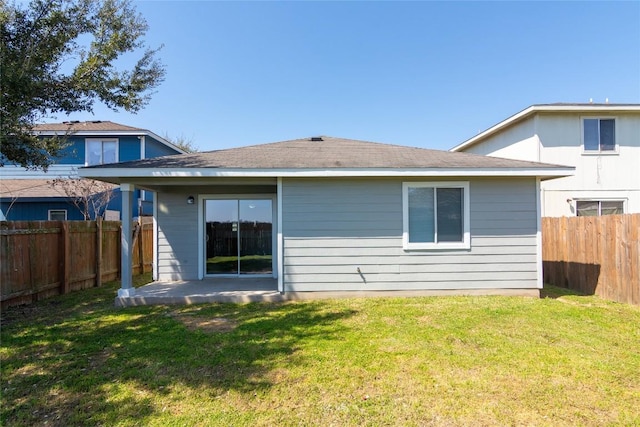 back of house with a lawn and a fenced backyard