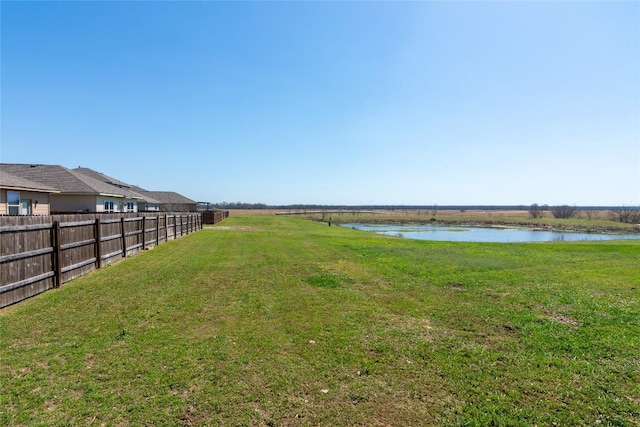 view of yard with fence and a water view