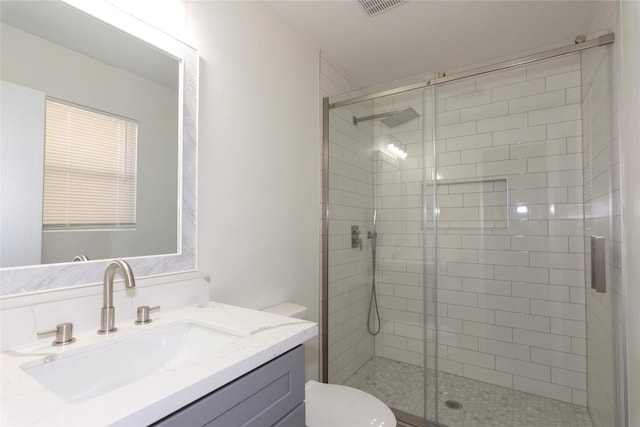 full bathroom featuring visible vents, a shower stall, toilet, and vanity