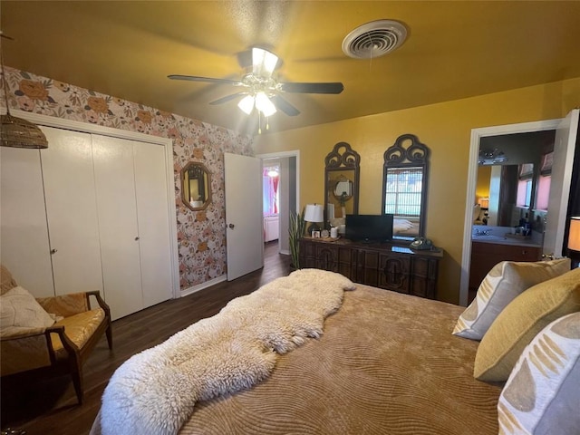 bedroom with wood finished floors, visible vents, wallpapered walls, ceiling fan, and a closet