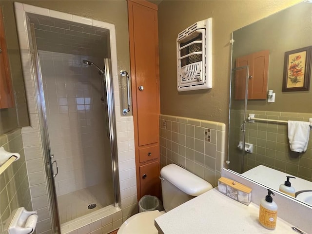 full bathroom with vanity, tile walls, toilet, and a stall shower