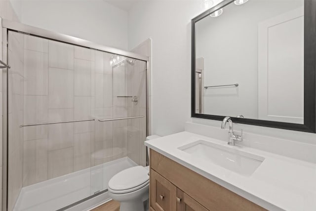 bathroom with vanity, toilet, and a stall shower