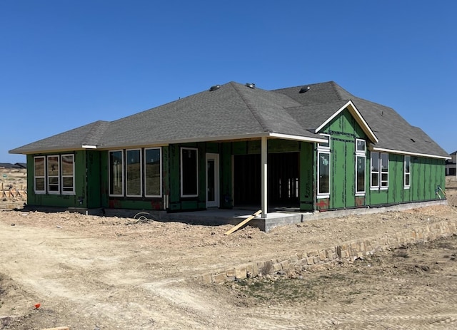 back of house featuring a shingled roof