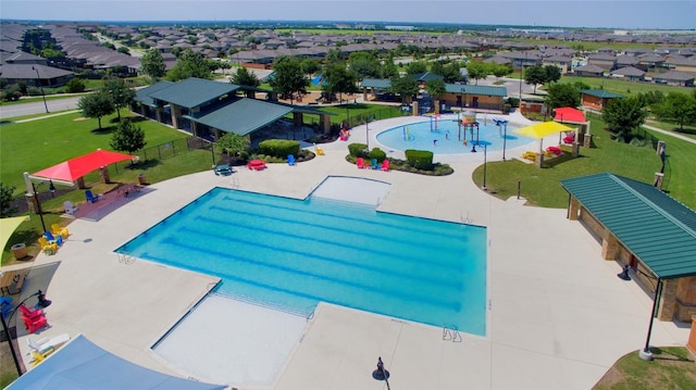 view of swimming pool featuring a patio area, a residential view, and fence