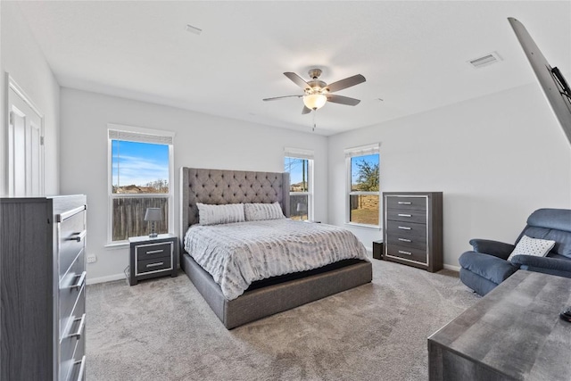 bedroom with visible vents, light carpet, baseboards, and a ceiling fan