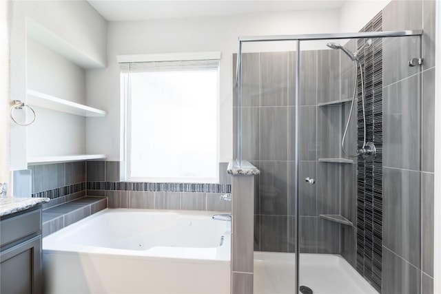 bathroom featuring vanity, a stall shower, and a whirlpool tub