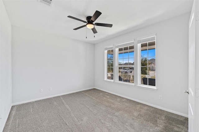 empty room with a ceiling fan, carpet flooring, baseboards, and visible vents