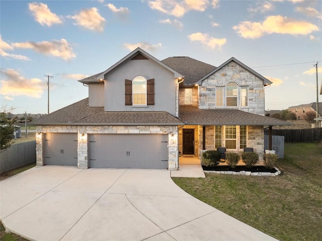 view of front of house featuring stone siding, concrete driveway, a front yard, and fence