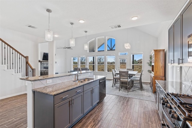 kitchen with a ceiling fan, wood tiled floor, gray cabinetry, a sink, and appliances with stainless steel finishes