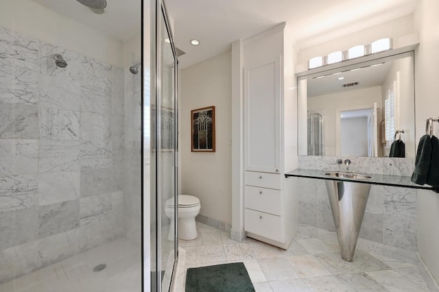 full bathroom featuring a shower stall, baseboards, visible vents, and a sink