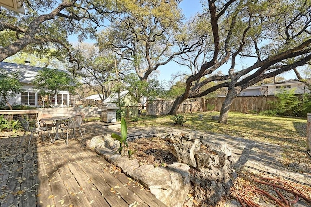 view of yard with outdoor dining area, a deck, and fence