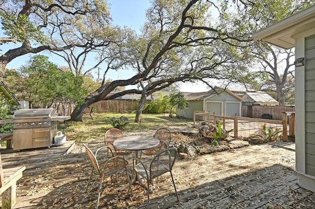 view of patio / terrace with an outbuilding, area for grilling, outdoor dining space, and fence