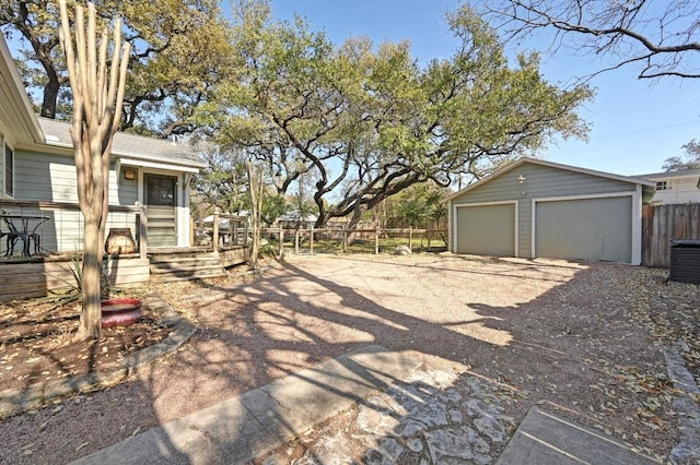 view of yard with an outbuilding, a garage, and fence