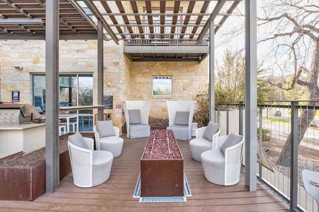 wooden deck featuring a fire pit and area for grilling