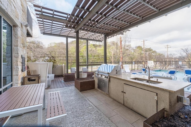 view of patio / terrace featuring fence, exterior kitchen, a pergola, a sink, and a grill