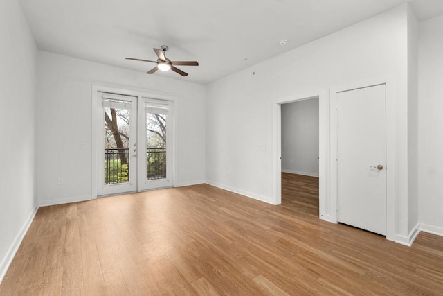 empty room featuring a ceiling fan, light wood-type flooring, and baseboards