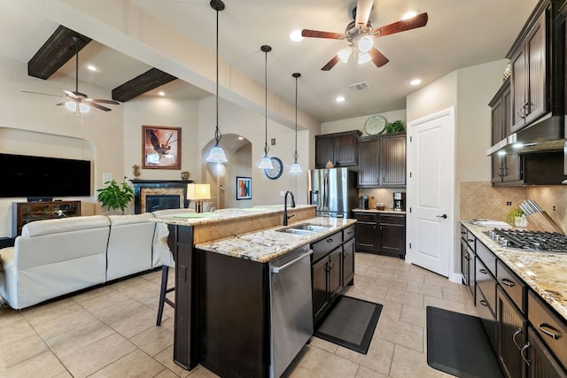 kitchen with a sink, stainless steel appliances, open floor plan, and a ceiling fan