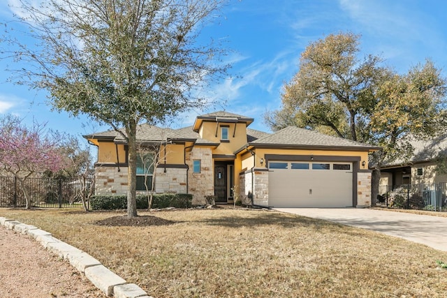 prairie-style home with stone siding, stucco siding, an attached garage, and concrete driveway