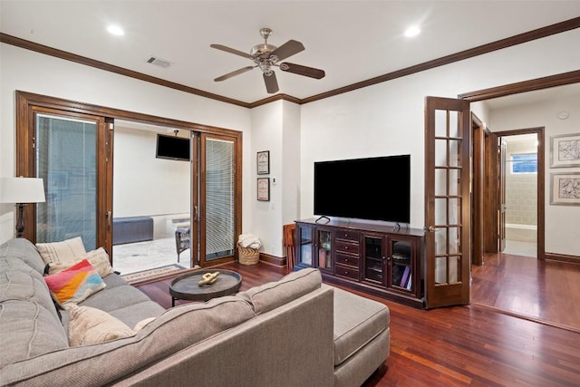 living area with visible vents, wood finished floors, baseboards, and ceiling fan