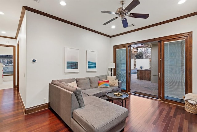 living area featuring visible vents, dark wood finished floors, crown molding, baseboards, and ceiling fan