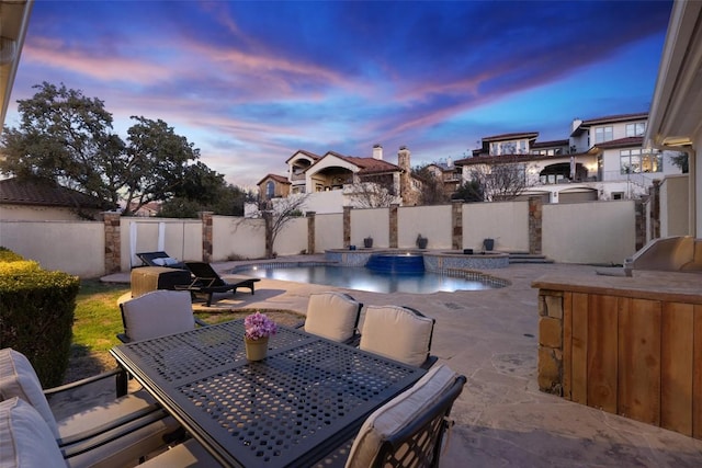 pool at dusk with outdoor dining area, a fenced in pool, a fenced backyard, and a patio area