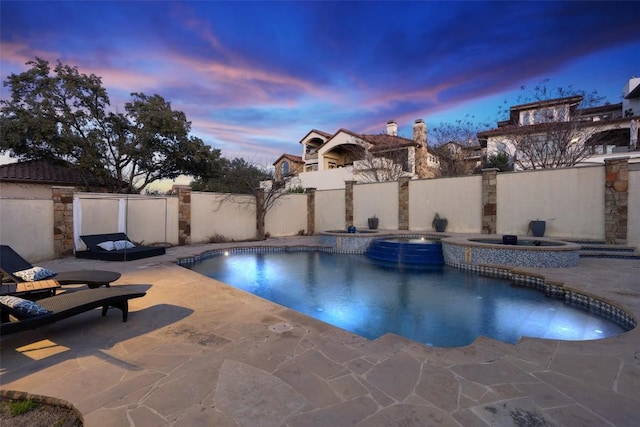 view of pool featuring a patio area, a pool with connected hot tub, and fence