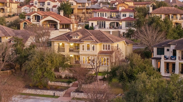 exterior space featuring stucco siding, a residential view, a balcony, and a tiled roof