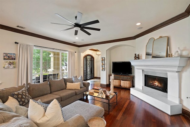 12027 Pleasant Panorama Vw, Austin, TX 78738 - living area featuring arched walkways, wood finished floors, ceiling fan, ornamental molding, and a warm lit fireplace
