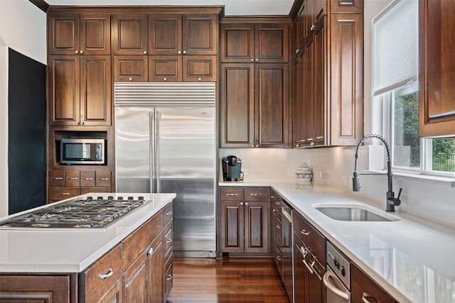 12027 Pleasant Panorama Vw, Austin, TX 78738 - kitchen with built in appliances, light countertops, dark wood-style floors, a kitchen island, and dark brown cabinetry