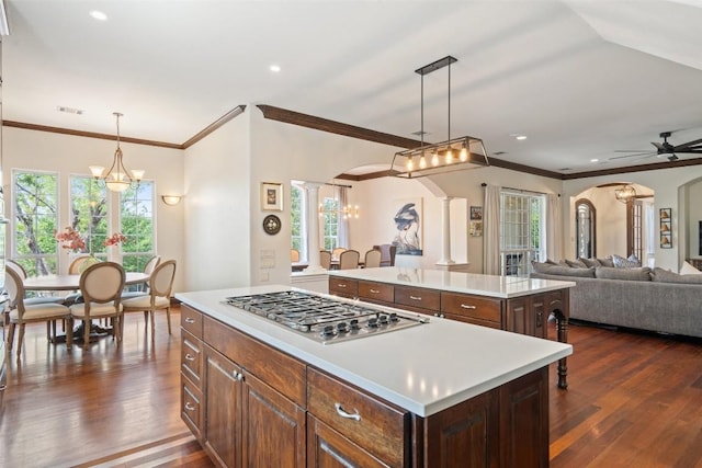 12027 Pleasant Panorama Vw, Austin, TX 78738 - kitchen with arched walkways, stainless steel gas cooktop, a center island, ornate columns, and ornamental molding