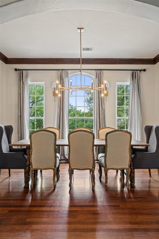 12027 Pleasant Panorama Vw, Austin, TX 78738 - dining space with crown molding, a chandelier, and wood finished floors