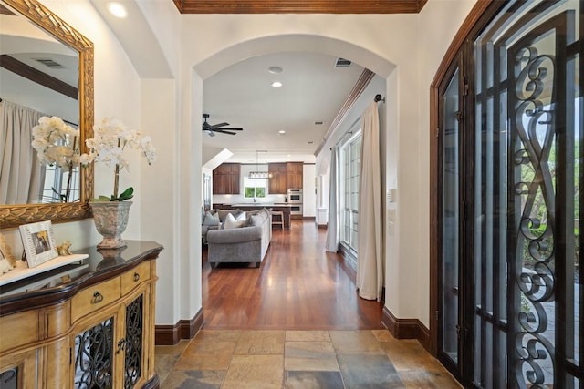 12027 Pleasant Panorama Vw, Austin, TX 78738 - foyer entrance featuring ornamental molding, arched walkways, ceiling fan, stone tile flooring, and recessed lighting